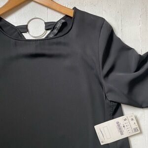 In style for the holiday. 
Stylish Black dress with Silver Ring Accents.